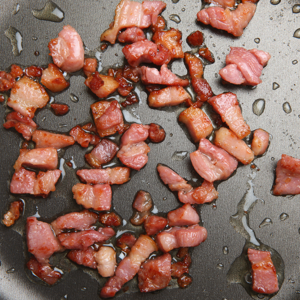 Cooking in a frying pan, sizzling Diced Pancetta cubes available to buy online with Aberdeenshire Larder